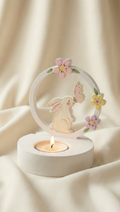 Decorative candle holder with rabbits and flowers on a soft beige background