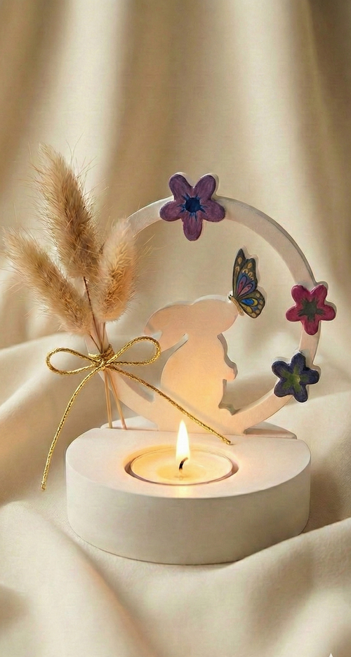Decorative candle holder with flowers, butterfly, and pampas grass on a beige background